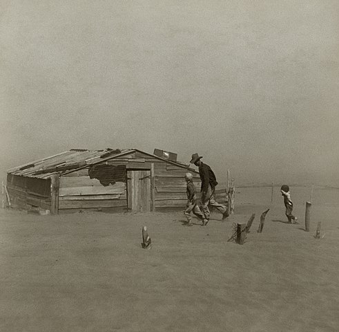 Farmer and sons walking in the face of a dust storm during the Dust Bowl weather event in the USA